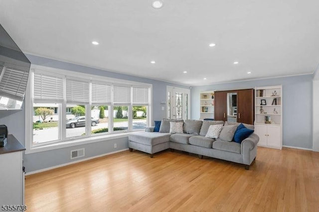 living area with light wood-style flooring, baseboards, recessed lighting, and ornamental molding