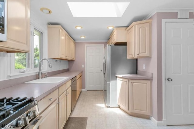 kitchen featuring a sink, stainless steel appliances, light brown cabinetry, a skylight, and light countertops