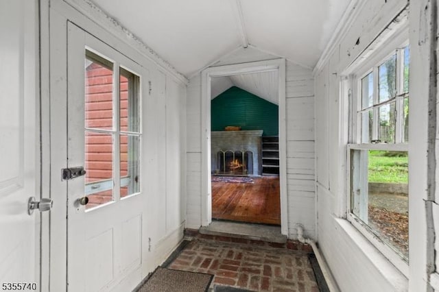 194 James St, Morris Twp, NJ 07960 - doorway with vaulted ceiling, brick flooring, and a lit fireplace