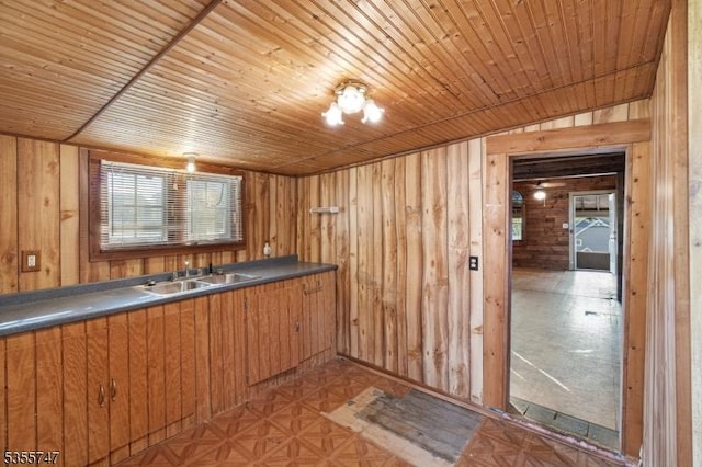 55 E Shore Culver Rd, Frankford Twp, NJ 07826 - kitchen with a sink, brown cabinetry, wood walls, and dark countertops