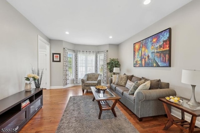 living room featuring recessed lighting, wood finished floors, and baseboards