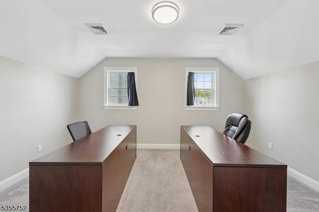 unfurnished office with lofted ceiling, baseboards, and light carpet