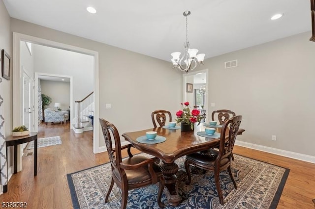 dining room featuring stairway, light wood-style flooring, a chandelier, baseboards, and recessed lighting