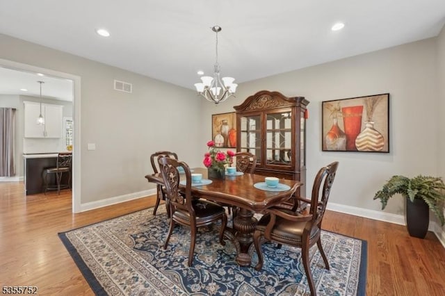 dining area with baseboards, light wood-style floors, recessed lighting, and a chandelier