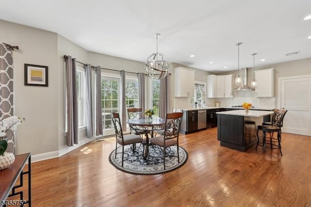 dining room with light wood-style floors, a chandelier, recessed lighting, and baseboards