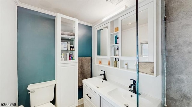 bathroom with double vanity, toilet, ornamental molding, and a sink