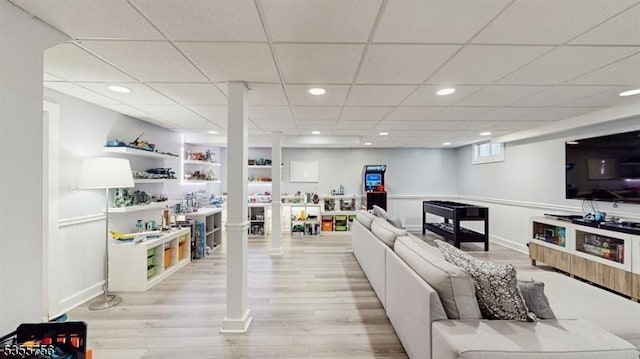 living area with a paneled ceiling, light wood-style flooring, baseboards, and recessed lighting