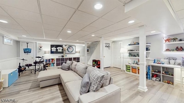 living area with recessed lighting, wood finished floors, and stairs