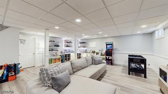 living room featuring recessed lighting, built in features, light wood-style flooring, and a paneled ceiling