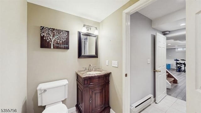 half bath with a baseboard radiator, toilet, baseboards, and vanity