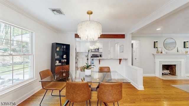 dining area featuring light wood-style floors, a chandelier, visible vents, and plenty of natural light