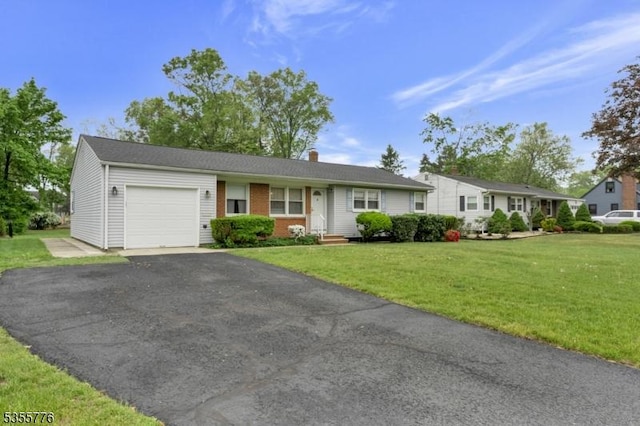 single story home with a garage, a front lawn, a chimney, and driveway