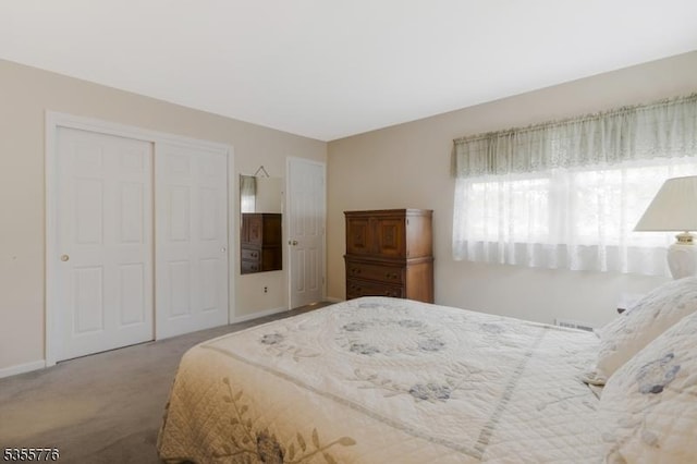 bedroom with a closet, carpet flooring, and baseboards