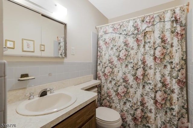 bathroom featuring toilet, vanity, and a shower with curtain