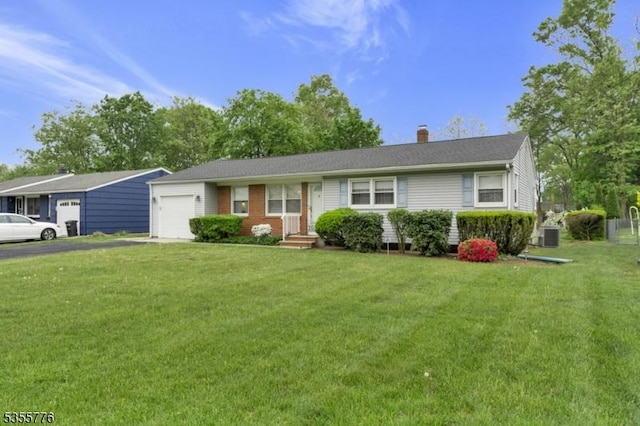 ranch-style house featuring a garage, a front lawn, driveway, and a chimney