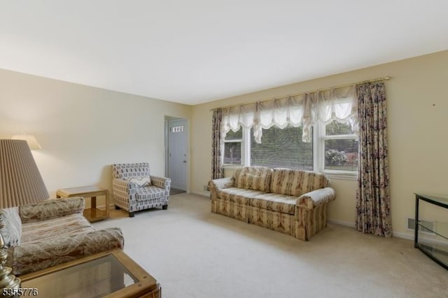 carpeted living area featuring baseboards