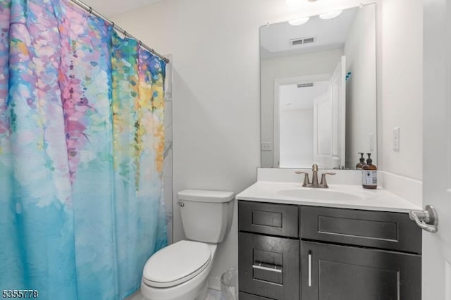 full bathroom featuring curtained shower, vanity, toilet, and visible vents