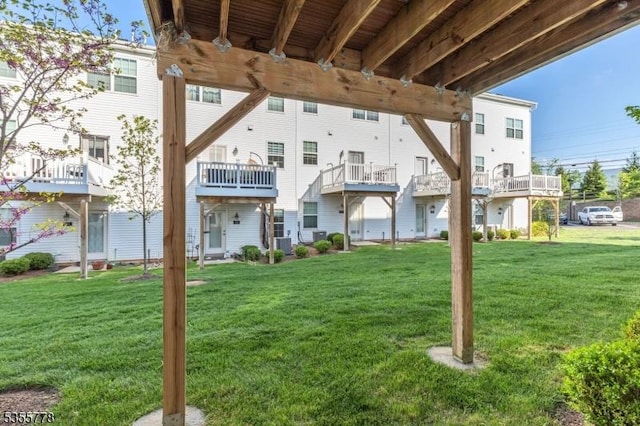rear view of property with central air condition unit and a yard