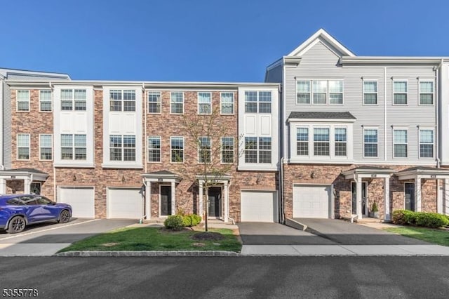 multi unit property featuring an attached garage and driveway
