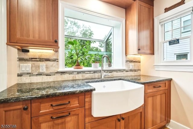 29 Rutgers St, Maplewood Twp, NJ 07040 - kitchen featuring a sink, decorative backsplash, brown cabinetry, and dark stone countertops