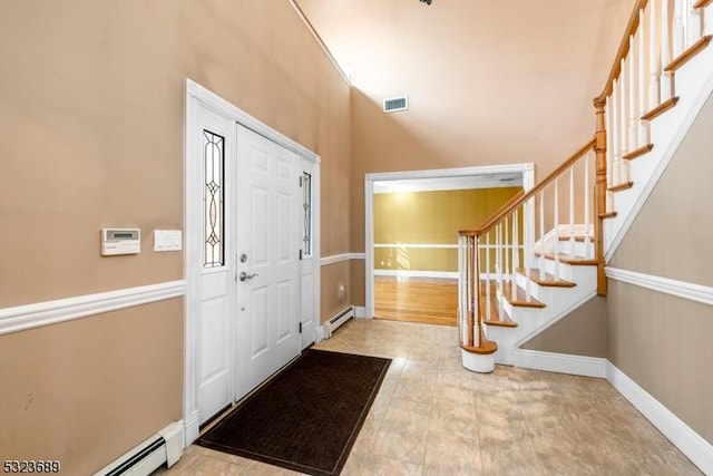 entryway featuring a baseboard heating unit, stairway, visible vents, and baseboards