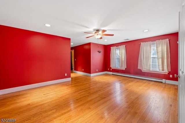 unfurnished room with a baseboard radiator, recessed lighting, baseboards, ceiling fan, and wood finished floors