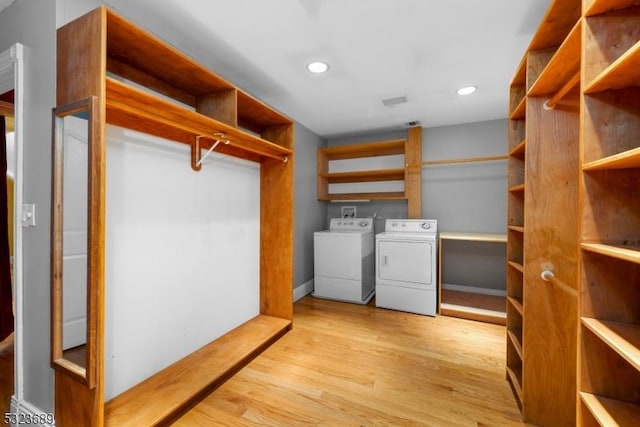clothes washing area with washing machine and dryer, light wood-style flooring, baseboards, and recessed lighting