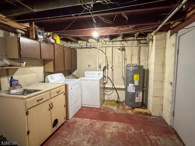 washroom featuring electric water heater, washer and dryer, and cabinet space