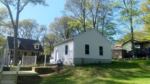 315 Tulsa Trl, Hopatcong Boro, NJ 07843 - view of side of property featuring a storage shed, a lawn, an outdoor structure, and a deck