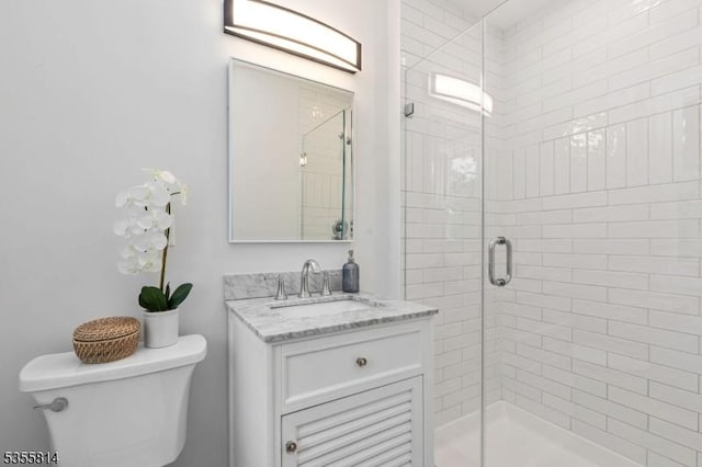 full bath with a shower stall, toilet, and vanity