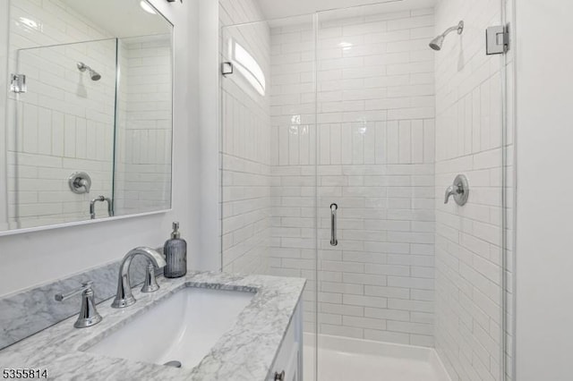 bathroom with a shower stall and vanity