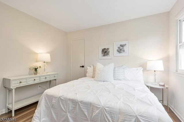 bedroom featuring wood finished floors and baseboards