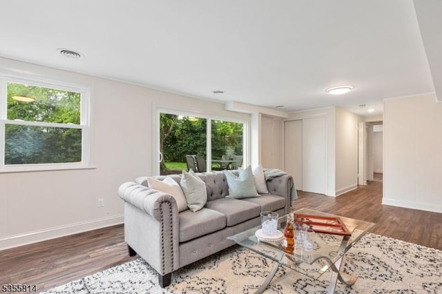 living area with wood finished floors, healthy amount of natural light, and baseboards
