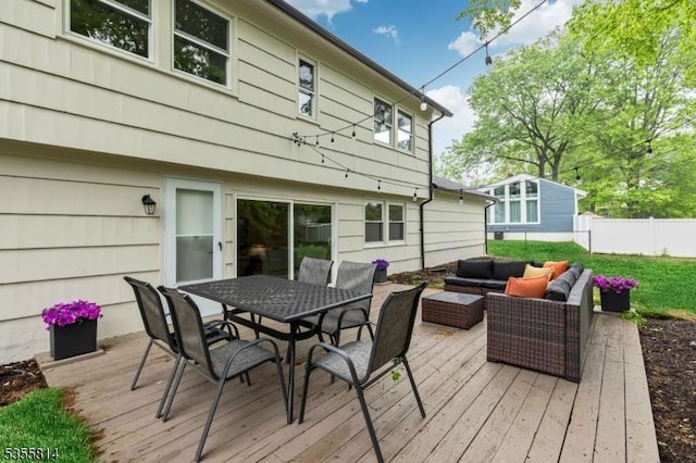 wooden terrace with an outdoor living space, fence, and outdoor dining space