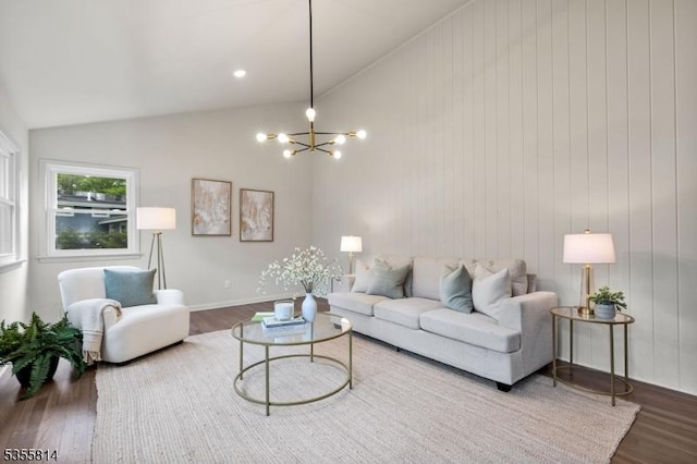 living room featuring lofted ceiling, wood finished floors, and a chandelier
