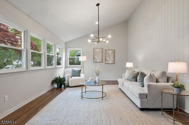 living room featuring wood finished floors, a chandelier, vaulted ceiling, and baseboards