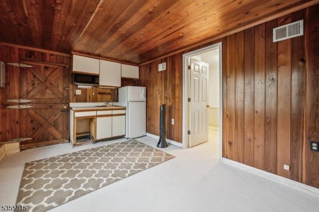 1078 Mountain Ave, Berkeley Heights Twp, NJ 07922 - kitchen with wooden ceiling, wooden walls, black microwave, freestanding refrigerator, and white cabinets