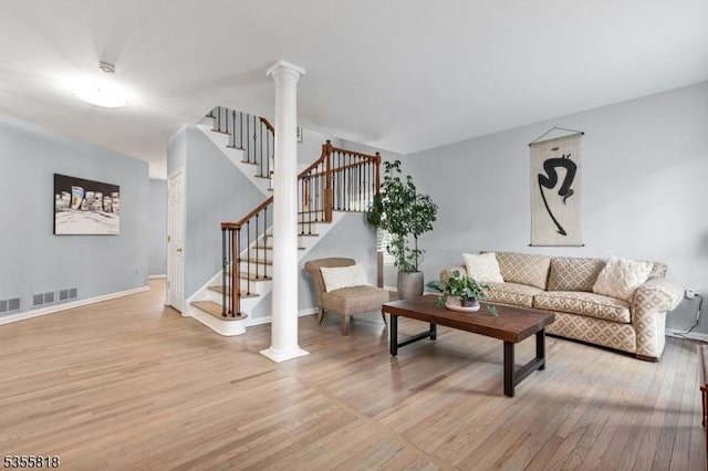living area with stairway, light wood-style flooring, baseboards, and visible vents