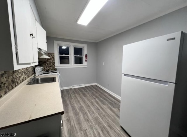kitchen featuring white appliances, tasteful backsplash, ventilation hood, white cabinetry, and light countertops