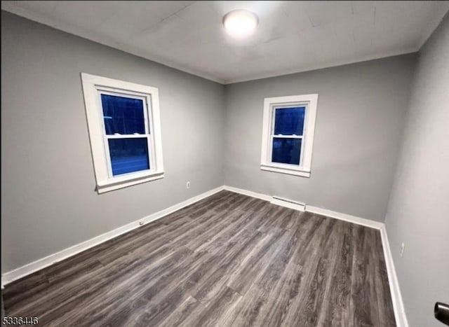 empty room with baseboards and dark wood-style floors