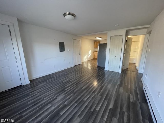 interior space featuring electric panel, baseboards, dark wood-type flooring, and a baseboard heating unit