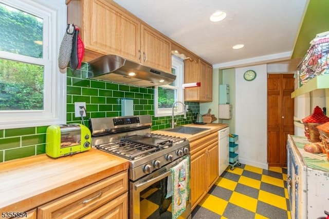 kitchen with stainless steel range with gas cooktop, a sink, under cabinet range hood, dishwasher, and backsplash
