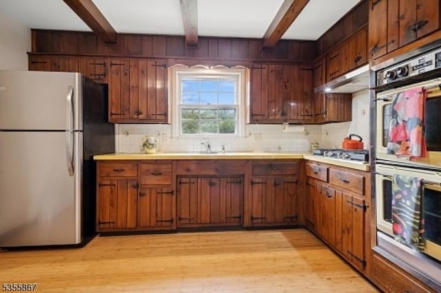 7 Fairhaven Dr, Parsippany-Troy Hills Twp, NJ 07950 - kitchen with appliances with stainless steel finishes, beamed ceiling, light wood-type flooring, backsplash, and light countertops