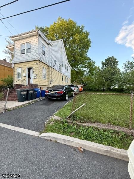 view of property exterior with a lawn and asphalt driveway
