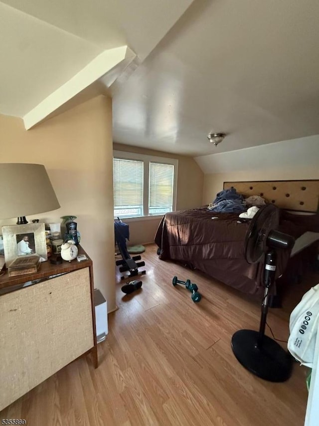bedroom with wood finished floors and vaulted ceiling
