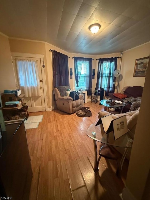living room with ornamental molding and light wood-type flooring