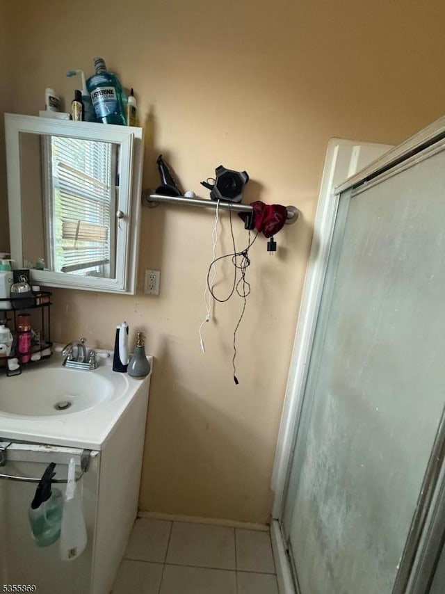 bathroom featuring tile patterned flooring, a stall shower, vanity, and baseboards