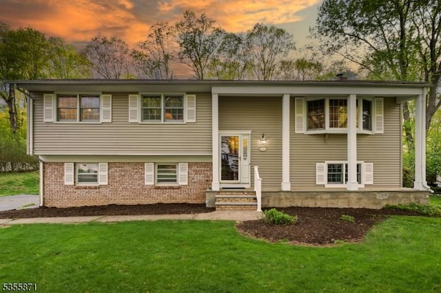 bi-level home with a front lawn and brick siding
