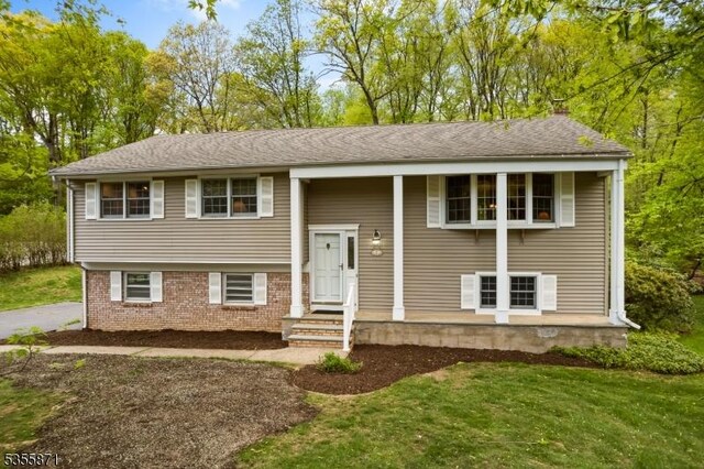 split foyer home with a front lawn and brick siding