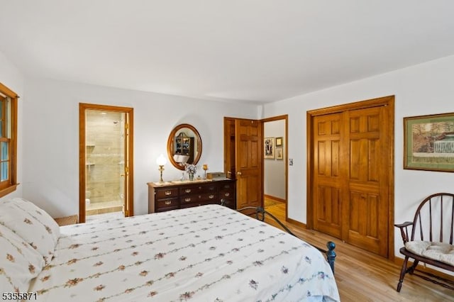 bedroom featuring light wood-type flooring, a closet, and ensuite bath
